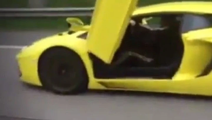 Lamborghini Aventador con la portiera aperta in autostrada