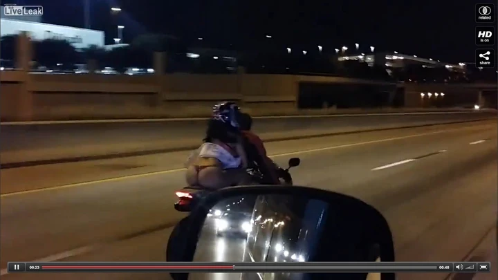 Donna con il gonnellino svolazzante in moto [Video]