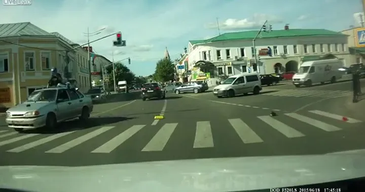 Motociclista sul tetto della macchina dopo l'incidente