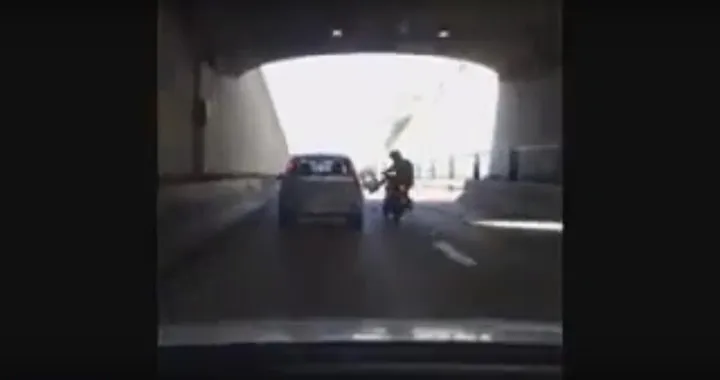 Motociclista prende a calci un'auto ma finisce a terra [Video]