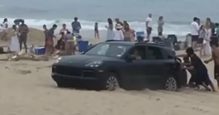 In spiaggia con la Porsche Cayenne: si insabbia e viene spinto [Video]