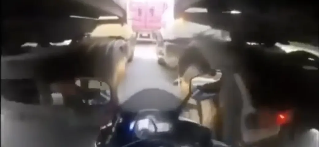 Video: tenta il sorpasso fra due camion, ma cade e la moto rimane schiacciata