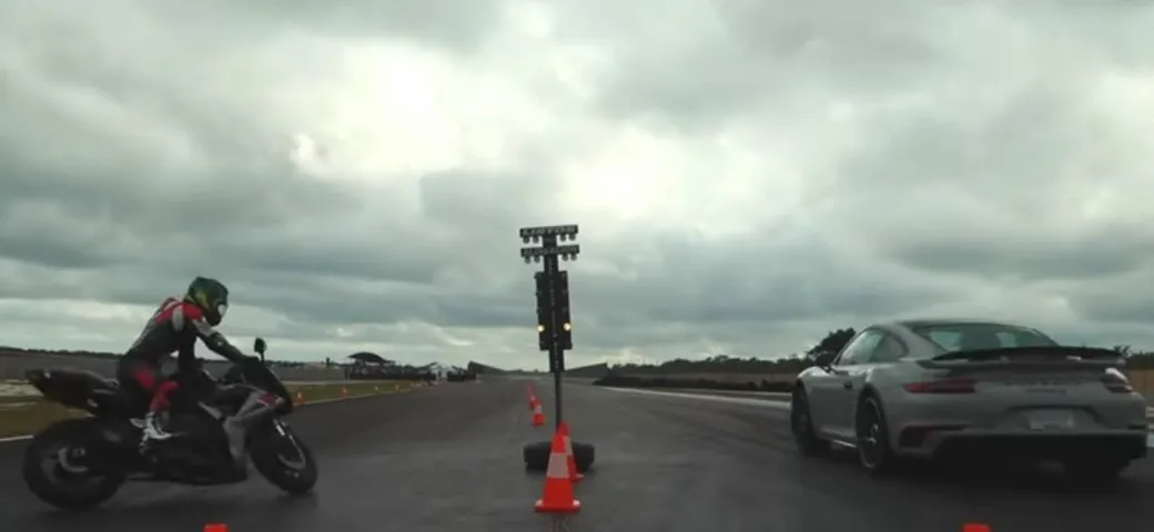 Con la moto sfida la Porsche in accelerazione ma cade a terra [Video]