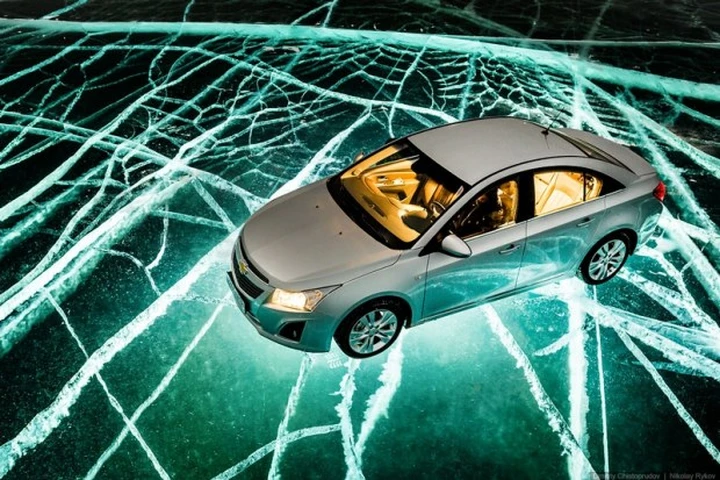 Russia: l'auto che viaggia di notte sul ghiaccio illuminato