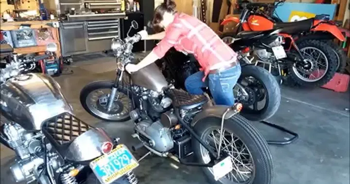 Ragazza cerca di mettere in moto una Harley