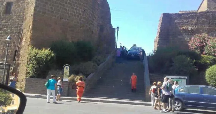 In auto tenta di scendere...la scalinata della chiesa!
