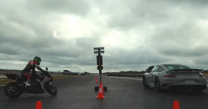 Con la moto sfida la Porsche in accelerazione ma cade a terra [Video]