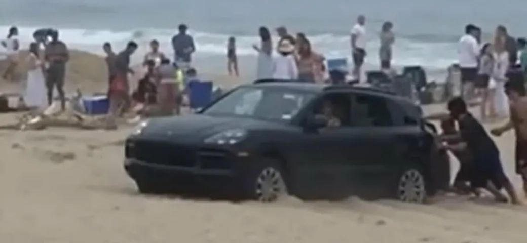 In spiaggia con la Porsche Cayenne: si insabbia e viene spinto [Video]
