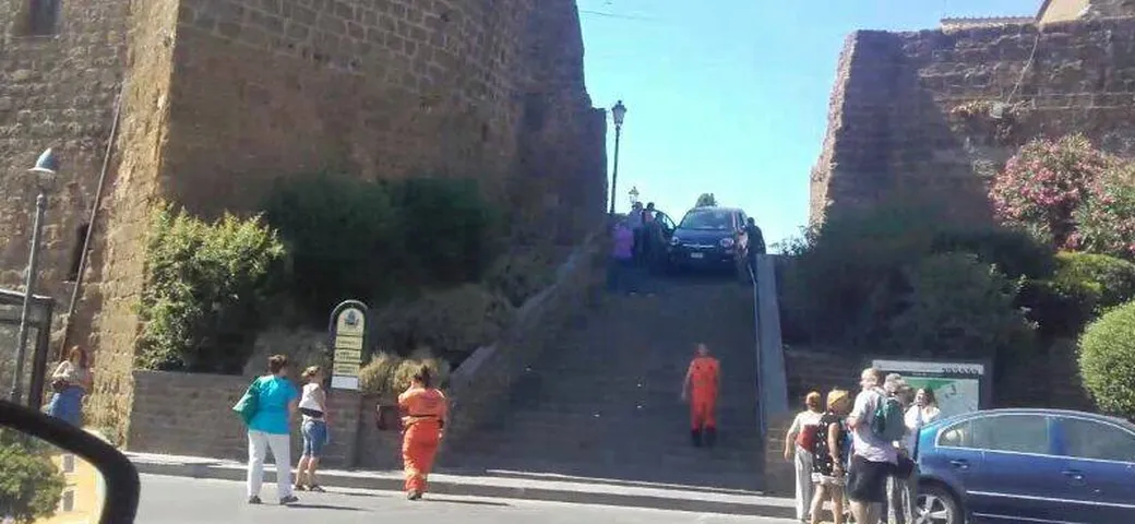 In auto tenta di scendere...la scalinata della chiesa!