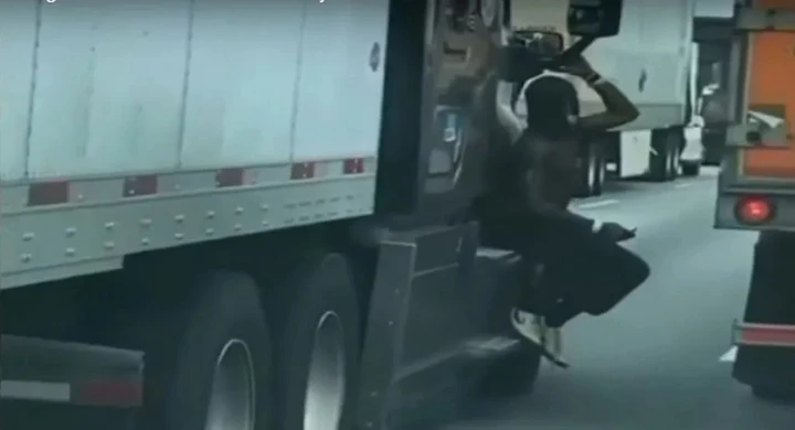 Cosa ci fa un uomo appeso al TIR in autostrada? [Video]