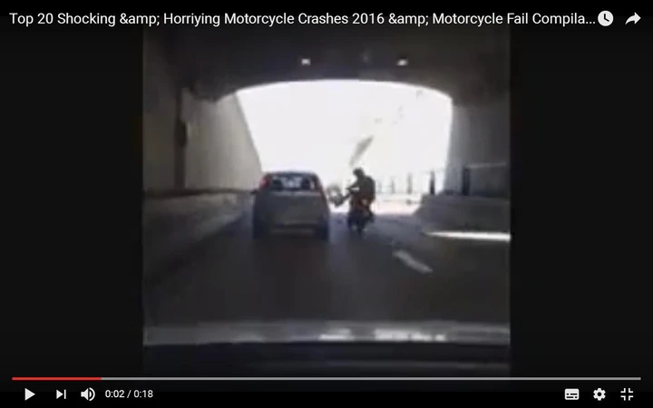 Motociclista prende a calci un'auto ma finisce a terra [Video]