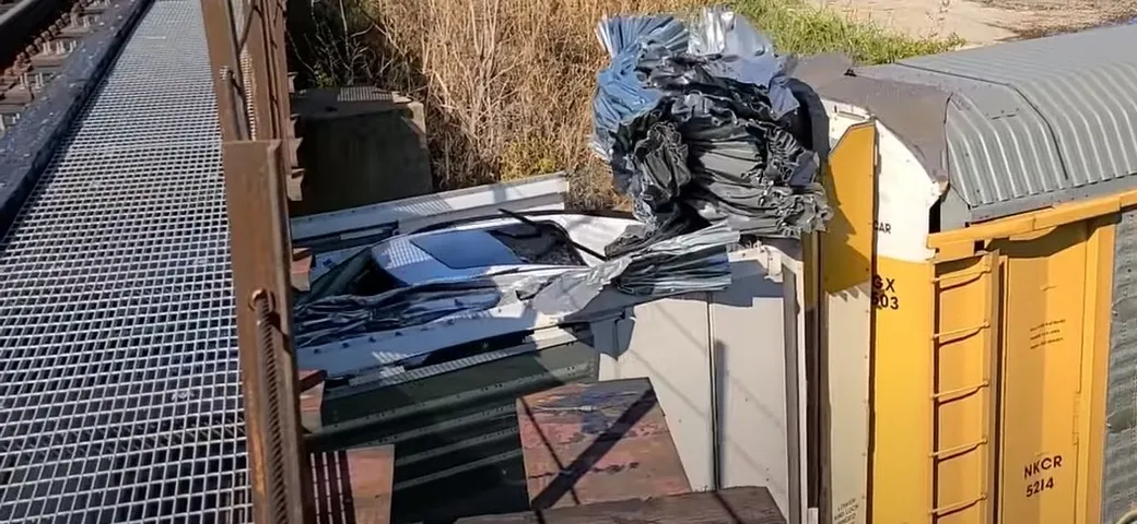 Treno merci più alto del ponte: decine di auto distrutte [Video]