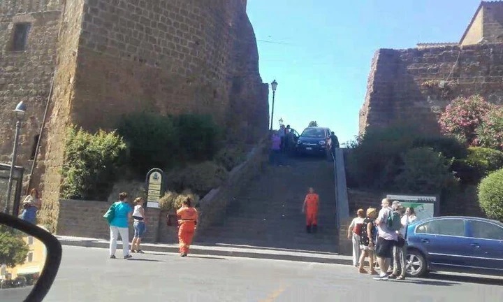 In auto tenta di scendere...la scalinata della chiesa!