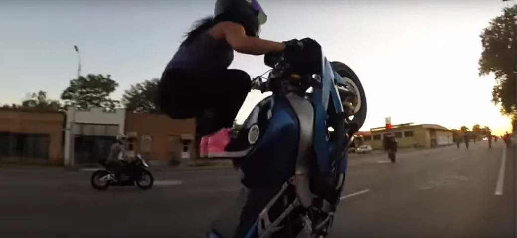 Ragazza spericolata fa impennate alla 007 in moto [Video]