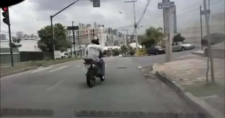 Motociclista dà un calcio a un\'auto ma finisce a terra