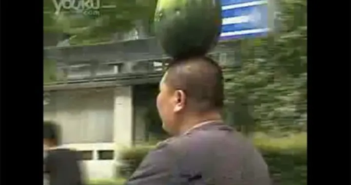 Nel traffico cinese con un'anguria sulla testa