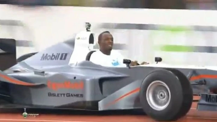 Usain Bolt guida (con difficoltà) la replica di una Formula 1