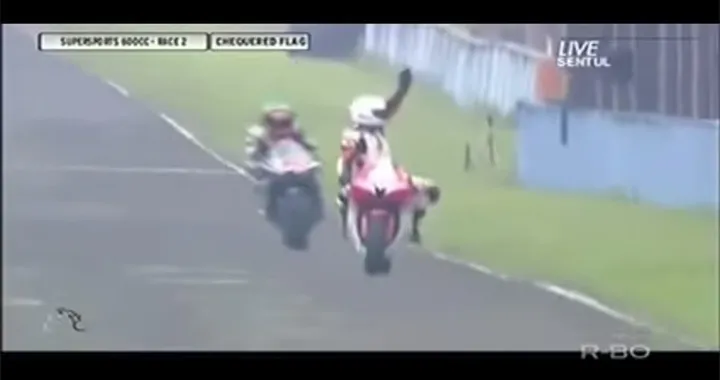 Taglia il traguardo ed esulta. Centrato in pieno dalla moto che segue [Video]