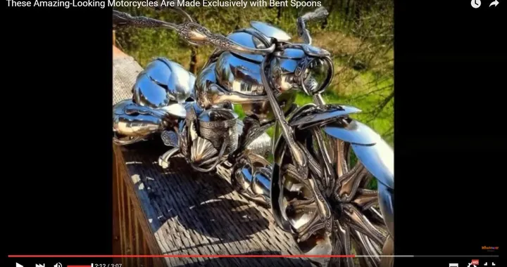 Scultura con soli cucchiai che riproduce in scala una moto