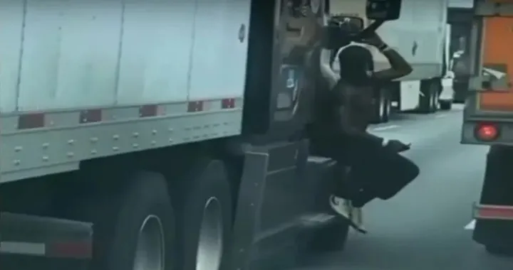Cosa ci fa un uomo appeso al TIR in autostrada? [Video]
