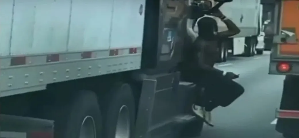 Cosa ci fa un uomo appeso al TIR in autostrada? [Video]