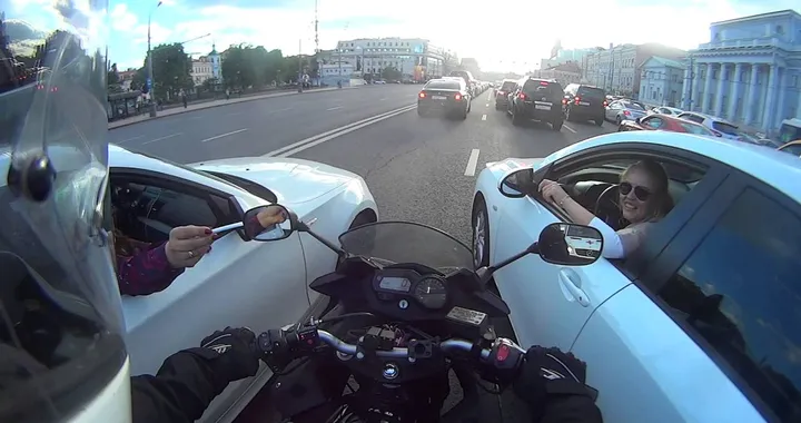 Motociclista fa da "ponte" tra due auto...