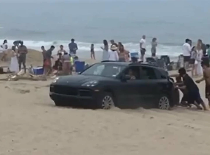 In spiaggia con la Porsche Cayenne: si insabbia e viene spinto [Video]