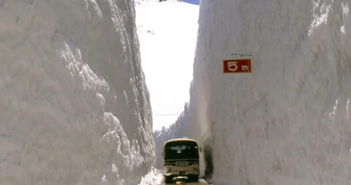 La strada in mezzo a due muraglie di neve alte come grattacieli