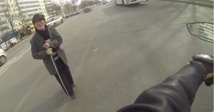 Ferma il traffico con la moto per far passare un anziano [Video]